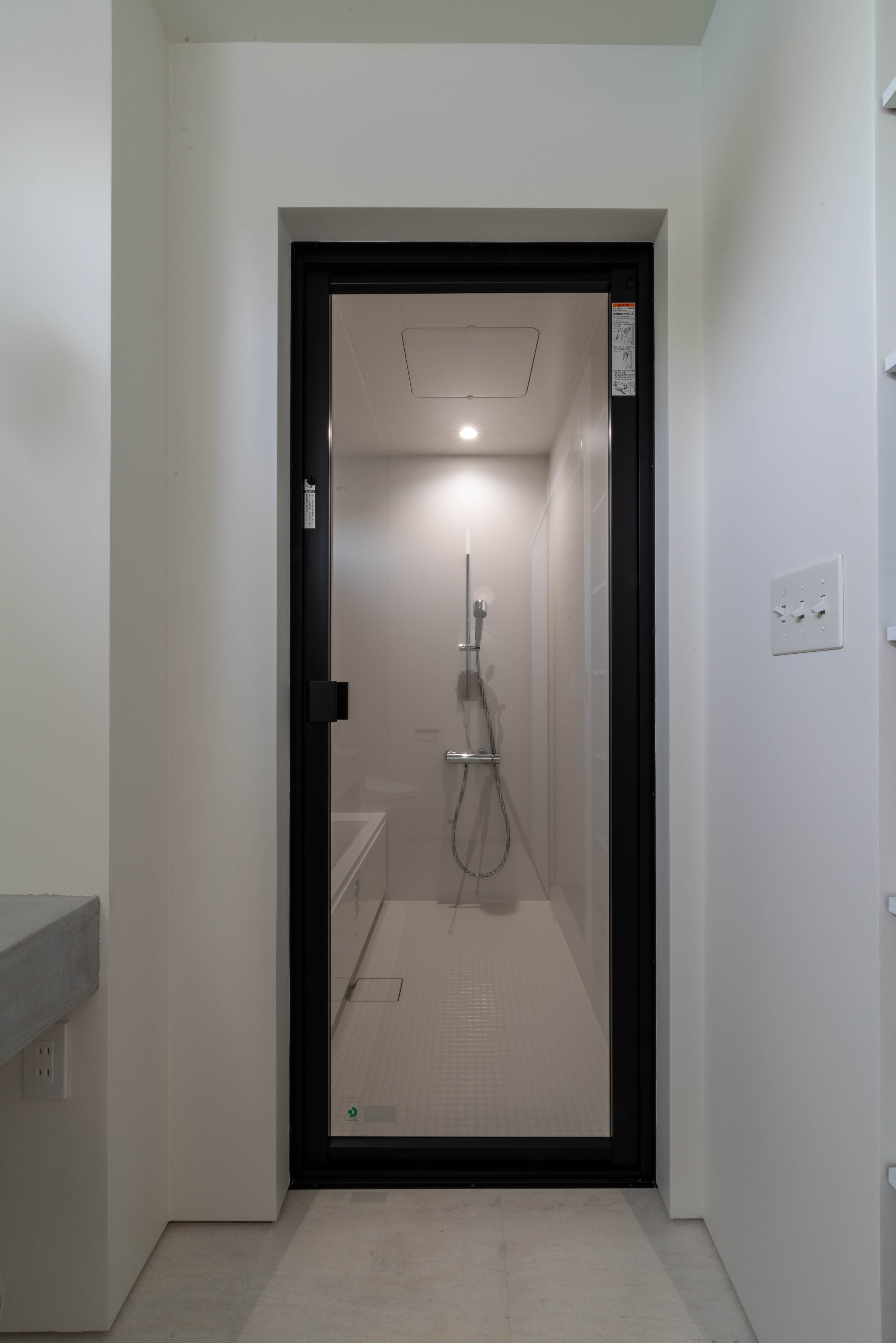 黒枠ガラスのシャワールームで、水回り全体の線を引き締める。