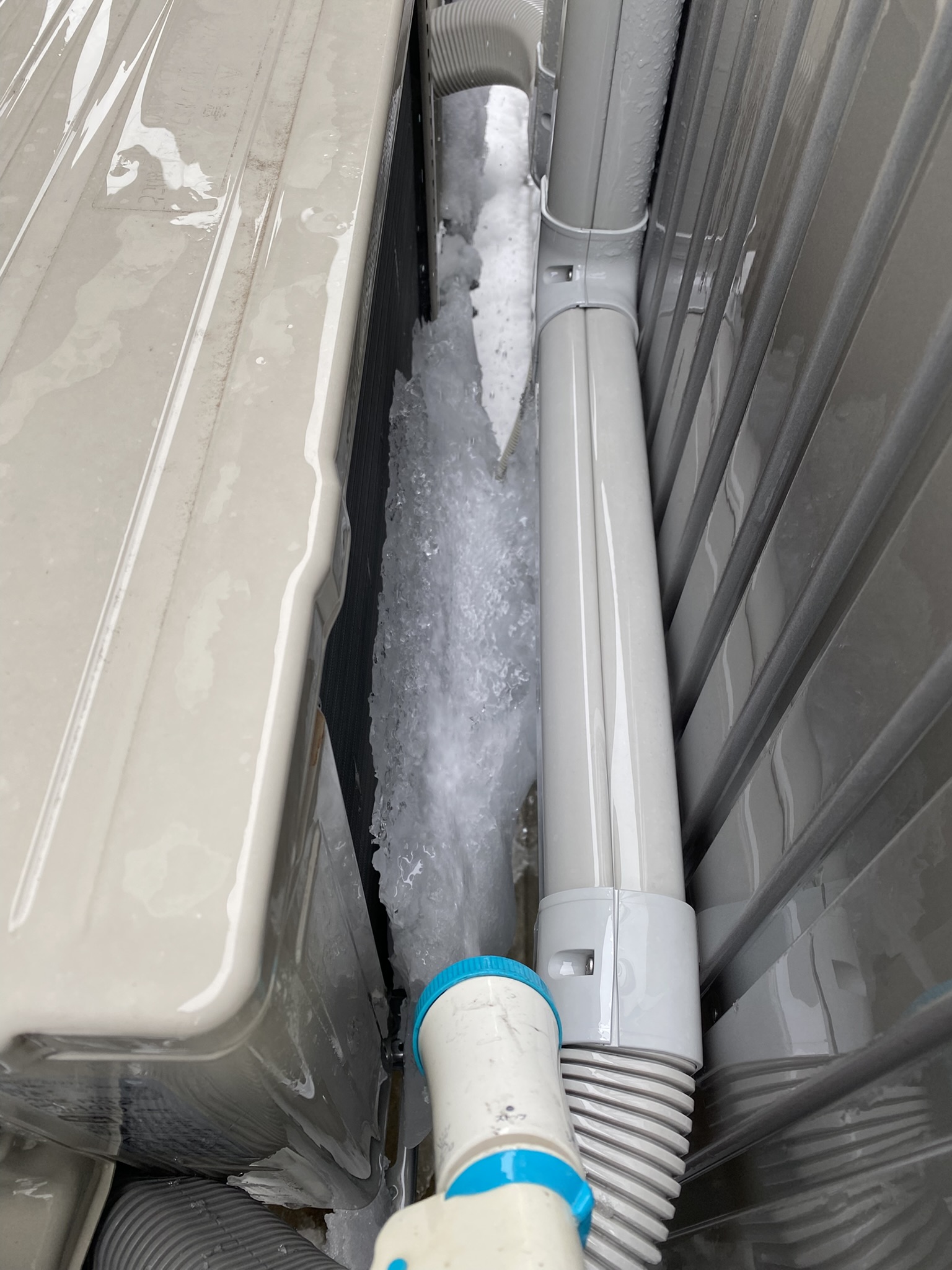 •	（写真：室外機の凍結／水で解氷）凍り始めの段階で、ホースの水で溶かしておくと安心です（※お湯はNG）