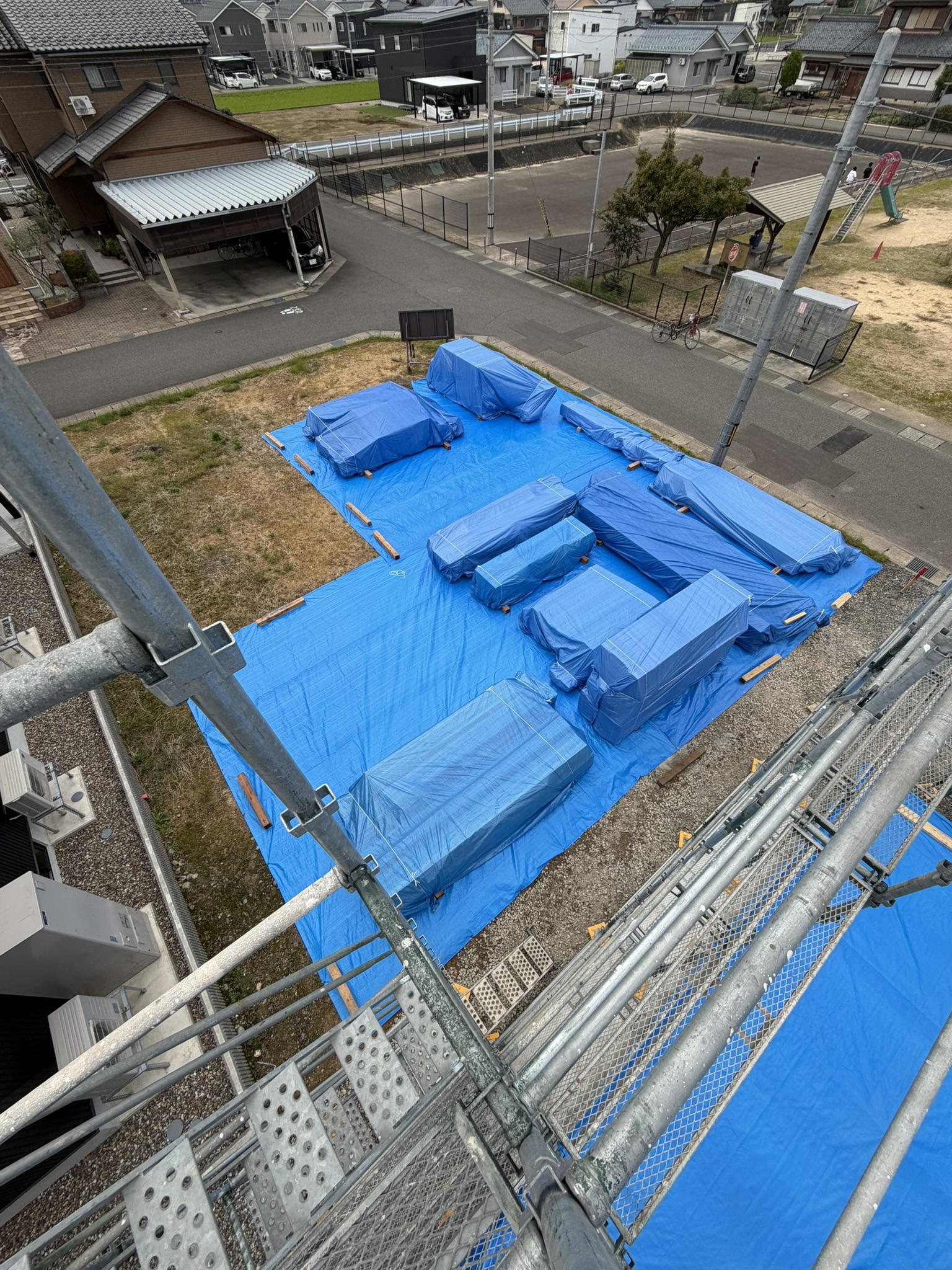 隣地をお借りし、地面を汚さないためのブルーシート養生。