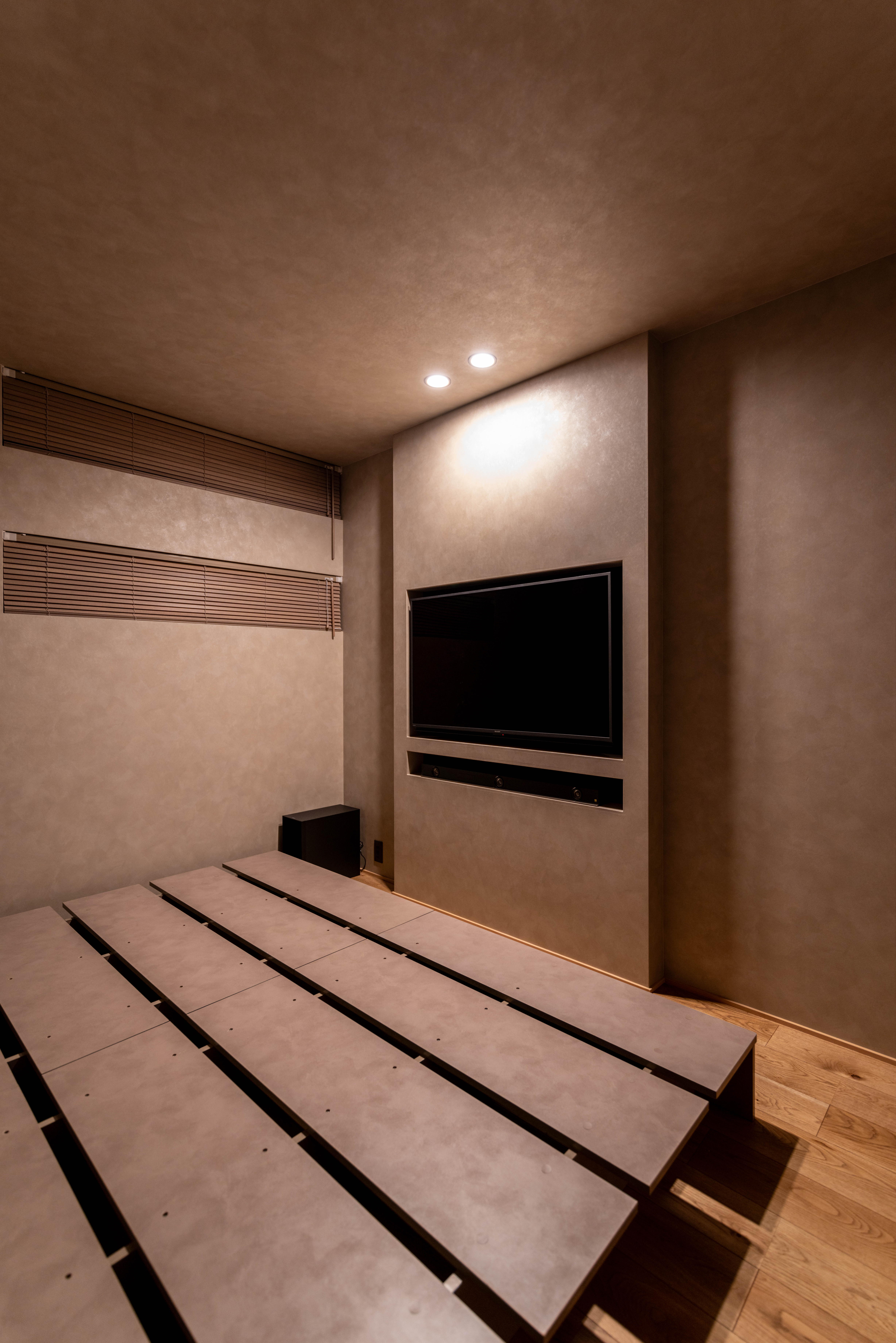 テレビとサウンドバーを壁にすっきり納めた寝室の正面。