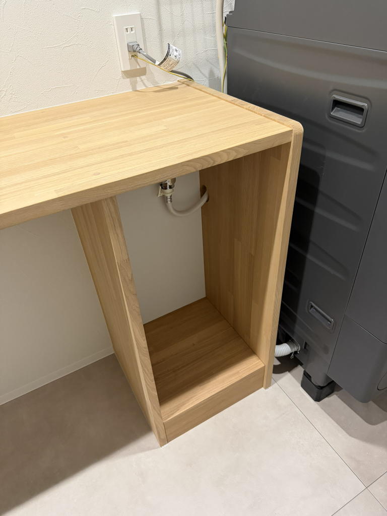 アイロン台カウンター下に納めた、配管隠し兼用の造作台。