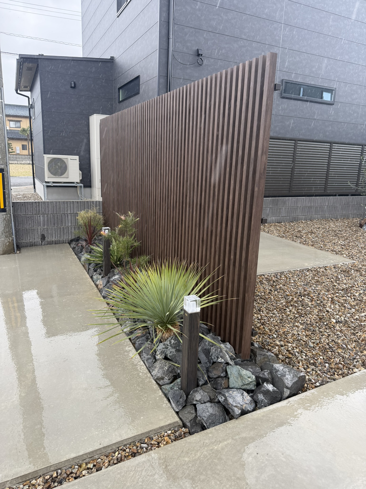 縦格子フェンスとロックガーデンが、建物正面の印象を美しく整えてくれました。