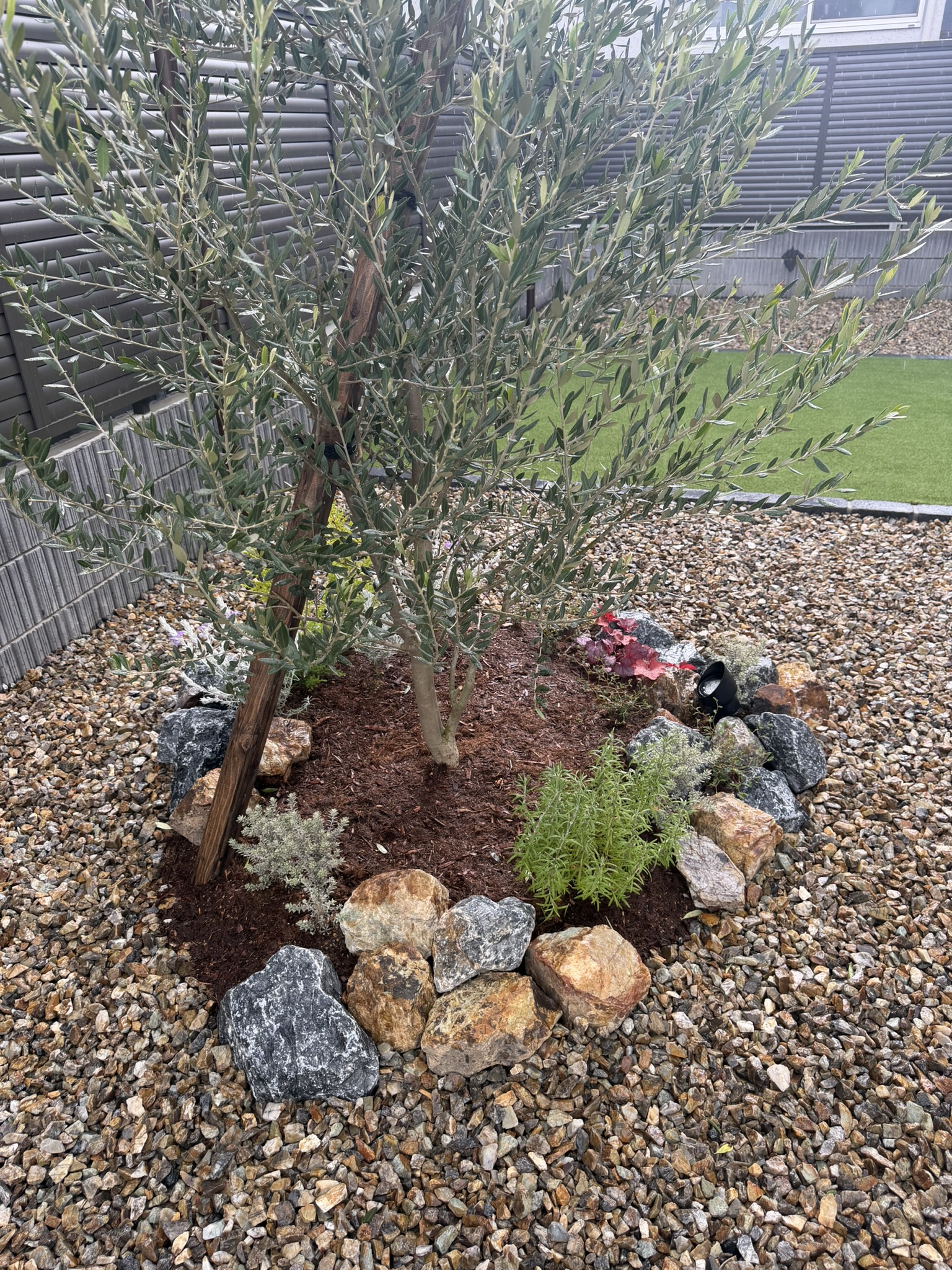 植栽と石の組み合わせが、外観にやわらかな表情を添えています。