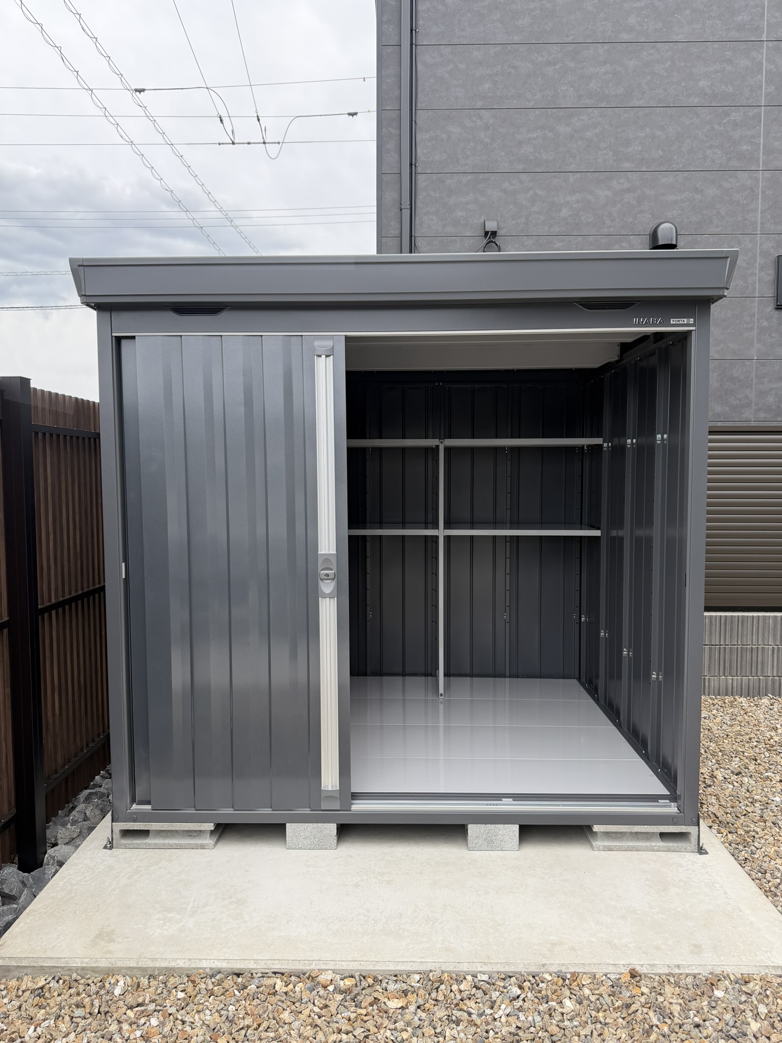 外観になじむフランネルグレーの物置が、すっきり納まりました。