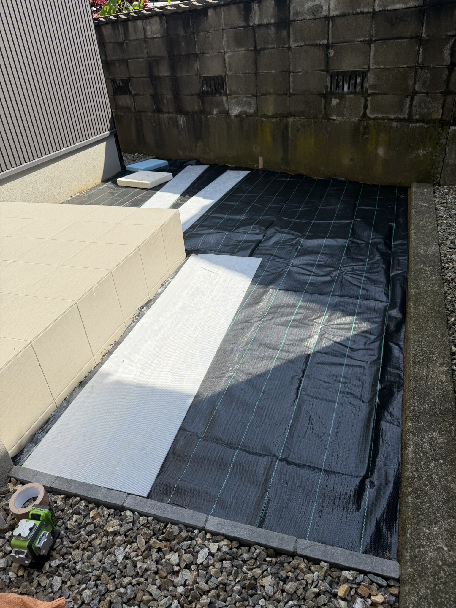 防草シートを敷き込み、人工芝を納める準備をしています。